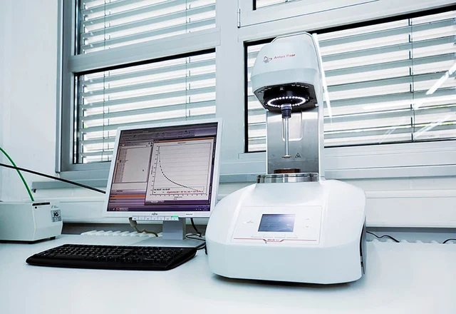Prüfgerät im Labor zur Bestimmung der Fliessfähigkeit von Druckfarbe mit angeschlossenem Computer.