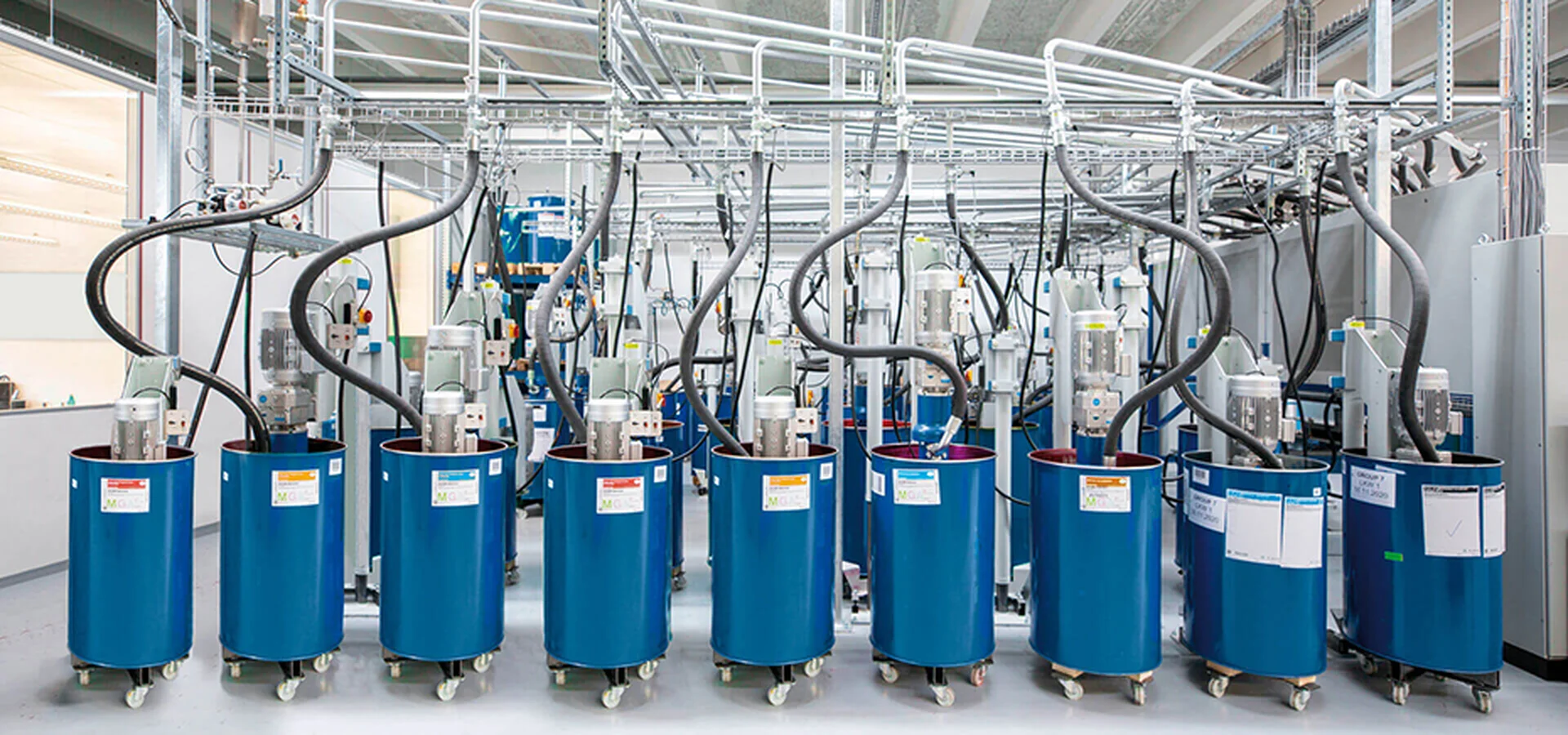 Automatische Farbmischanlage mit blauen Fässern in der Druckproduktion